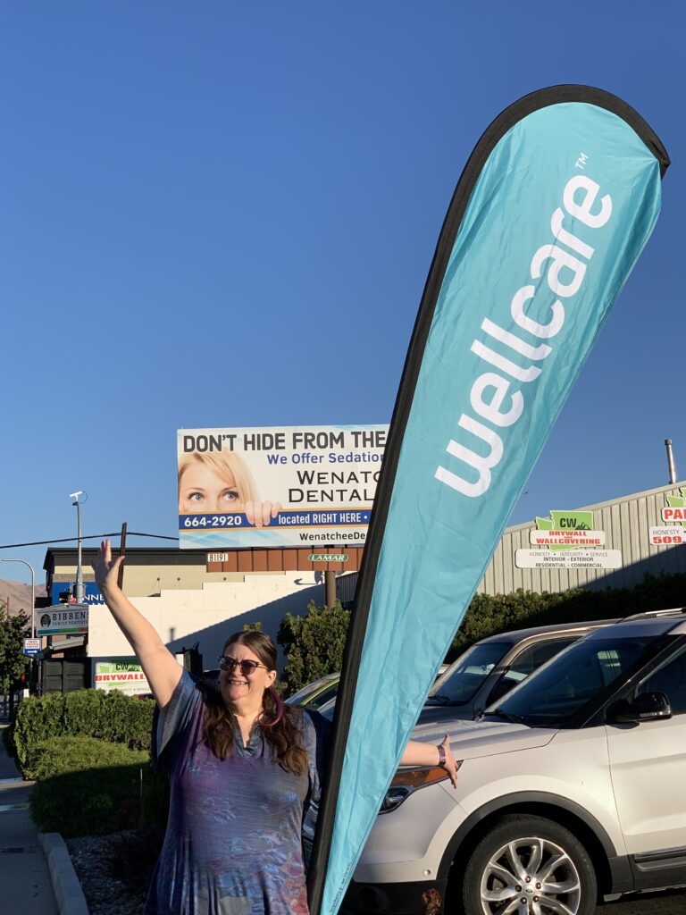 Suzie with the Wellcare banner on Mission for Fall Enrollment
